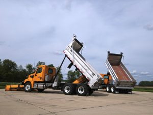 side view of both trucks with beds raised