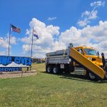 The Viking Cives Midwest Sign with a Dump body truck parked next to it.