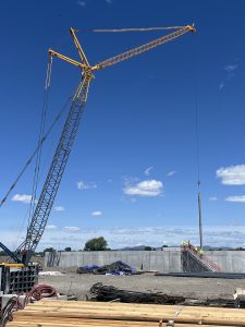 A crane lowers the first beam into place for the Teton River Temple project.