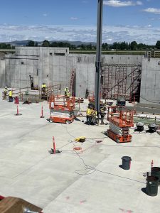 Workers position and fix the beam into place